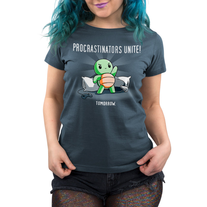 Premium Cotton T-shirt_TeeTurtle Procrastinators Unite! (Tomorrow) denim blue t-shirt featuring a green turtle standing on pillows with a game controller nearby, and text that reads, "Procrastinators Unite! Tomorrow."