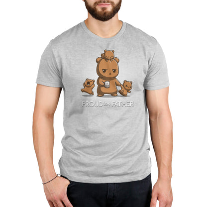 A person wearing a gray monsterdigital T-shirt that features an illustrated bear family with the text "Proud(ish) Father." The super soft ringspun cotton Proud(ish) Father shirt depicts a bear holding a cub with two more cubs climbing on it.
