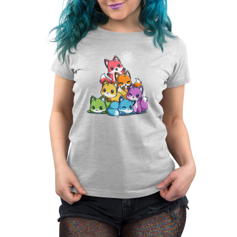 A person with blue hair wearing a light gray, super soft ringspun cotton monsterdigital T-shirt featuring a colorful cartoon Rainbow Foxes design. The person is also wearing black shorts.