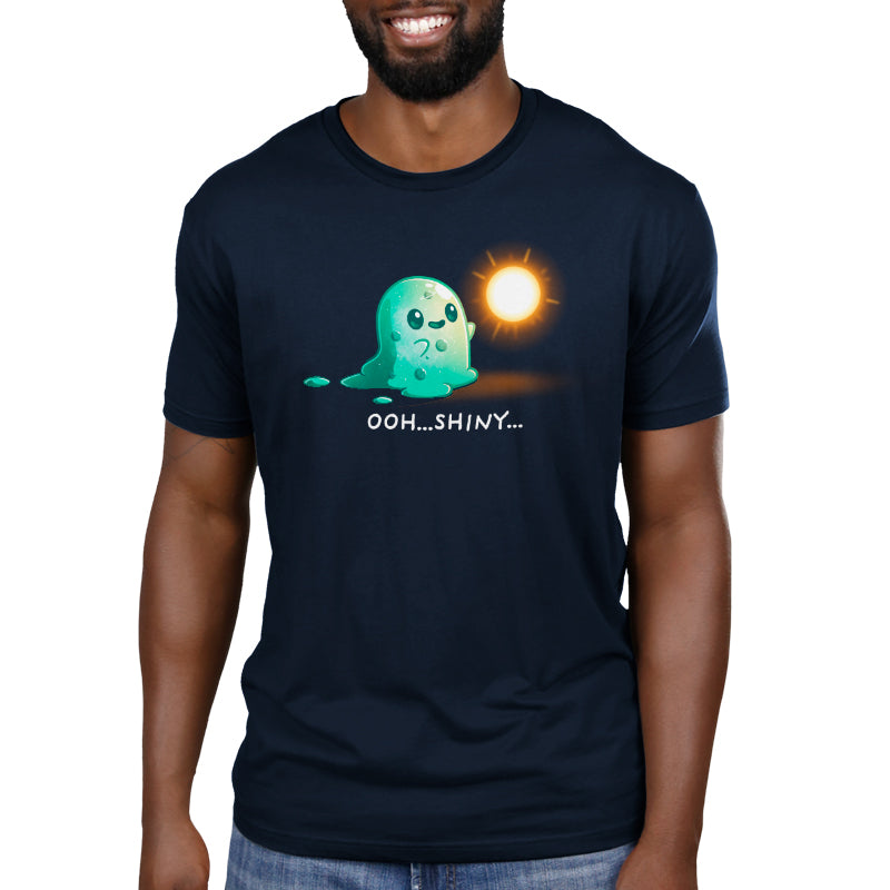 Man wearing a navy blue t-shirt featuring a graphic of a cartoon ghost mesmerized by a Shiny Distraction, with the text "ooh...shiny.." below it.