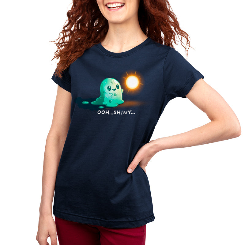 Woman in a navy blue t-shirt with a cartoon ghost graphic looking at the sun and text "ooh...Shiny Distraction...", smiling, with her hand on her hip. (monsterdigital)