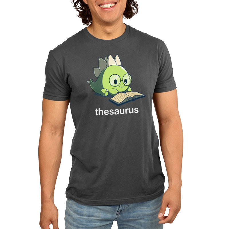 Premium Cotton T-shirt - Person wearing a charcoal gray apparel featuring an illustration of a dinosaur reading a book, with the word "Thesaurus" underneath the image, from monsterdigital.