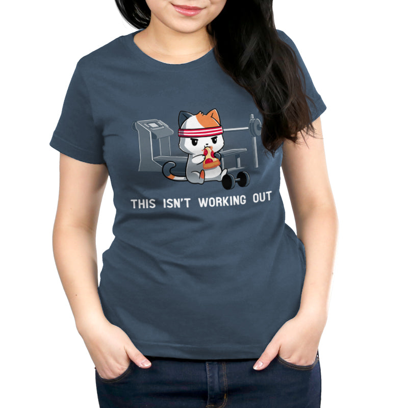 Premium Cotton T-shirt_Teeturtle This Isn't Working Out denim t-shirt featuring a cat wearing a headband, eating pizza in a gym with exercise equipment in the background. The text "This Isn't Working Out" is written below.