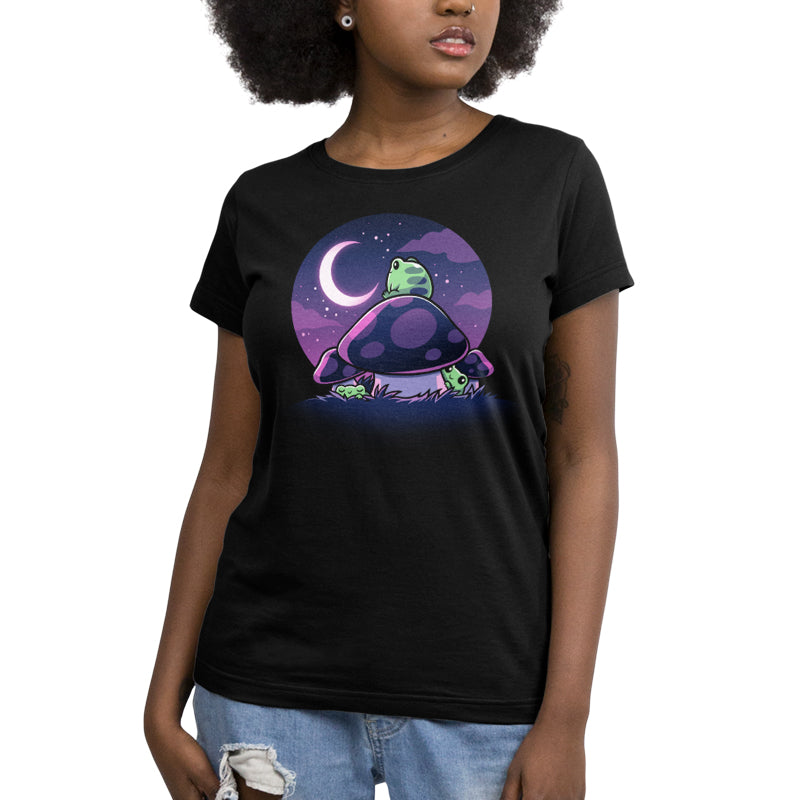 Premium Cotton T-shirt_TeeTurtle Twilight Toadstools black t-shirt featuring an illustration of a green frog sitting on top of a mushroom gazing up at the stars and a crescent moon in a violet-purple sky. There are two more green frogs underneath the mushroom cap, and two additional mushrooms on the side.