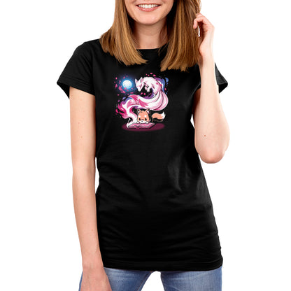 A person wearing a black "Tale of Tails" T-shirt from monsterdigital, featuring a colorful graphic of a fox and celestial elements, is smiling and touching their hair. This unisex tee is made from super soft ringspun cotton, ensuring comfort all day long.