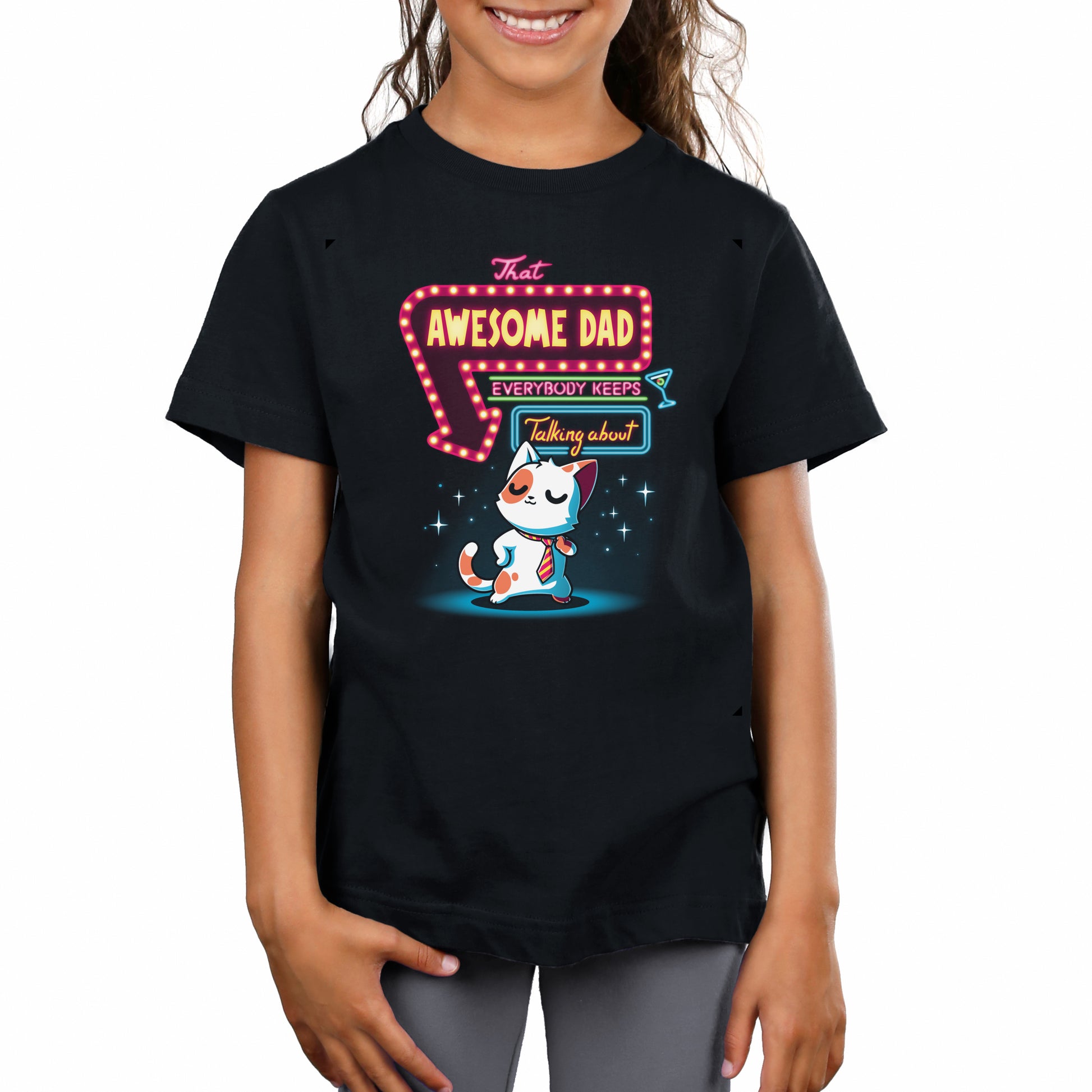 A person wearing a monsterdigital That Awesome Dad super soft ringspun cotton black T-shirt featuring a cartoon cat and the phrase "That AWESOME DAD everybody keeps talking about" printed on it.