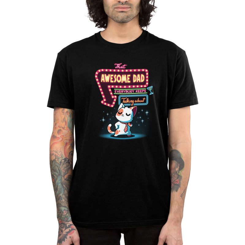 A person is wearing a super soft ringspun cotton black T-shirt with a colorful design featuring a cat and the text "That Awesome Dad Everybody Keeps Talking About," from monsterdigital's That Awesome Dad collection.