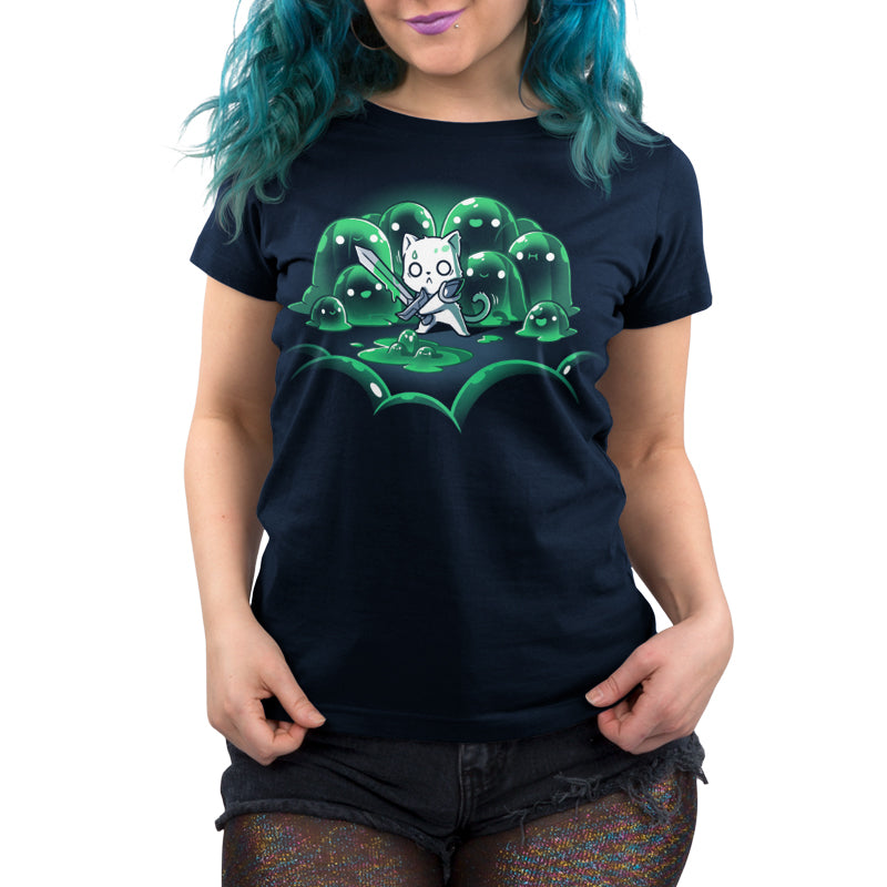 Person wearing a super soft ringspun cotton navy blue t-shirt with a cartoon cat character holding a sword, surrounded by green blobs, standing against a plain background. The t-shirt is called *The Never-Ending Fight* by *monsterdigital*.
