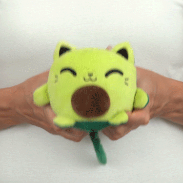 A person clutching a TeeTurtle Reversible Cat Plushmate (Avo-cat-o) from TeeTurtle.