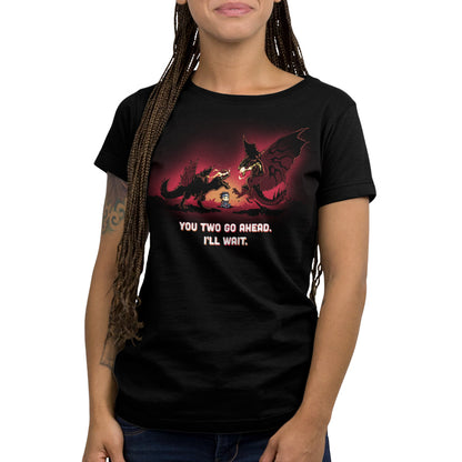 Premium Cotton T-shirt_TeeTurtle black You Two Go Ahead. I'll Wait apparel featuring two boss monsters from Monster Hunter having an intense fight, with a hunter sitting in the middle of their battlefield, and the caption, "You Two Go Ahead. I'll Wait".