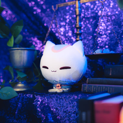 Cloudheads: 5" Mystic Moon (Vampurr). A white plush cat with closed eyes, a blue-gray collar, an orange accent on its head, and a smirk, shown with a sparkly purple backdrop as well as a leafy green plant and a pile of books. 
