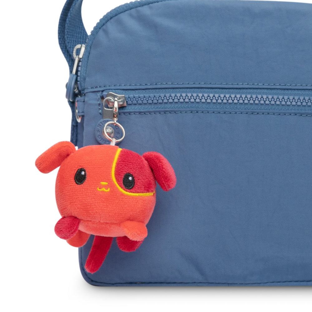 A TeeTurtle Lunar New Year-themed backpack with a TeeTurtle Lunar New Year Dog Plushie Charm Keychain hanging from it.