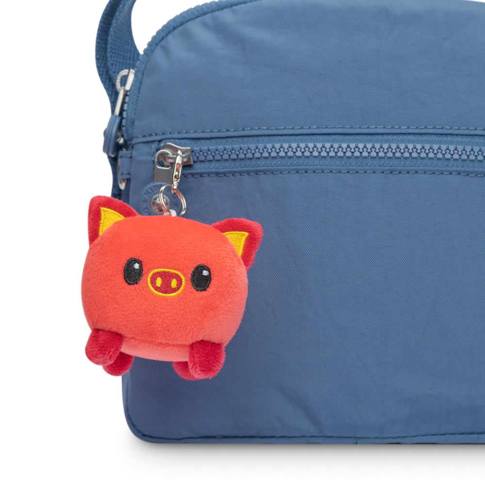 A TeeTurtle Lunar New Year backpack with a TeeTurtle Lunar New Year Pig Plushie Charm Keychain on it.