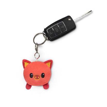 A TeeTurtle Lunar New Year Pig Plushie Charm Keychain with a plushie pig charm perfect for decorating backpacks.