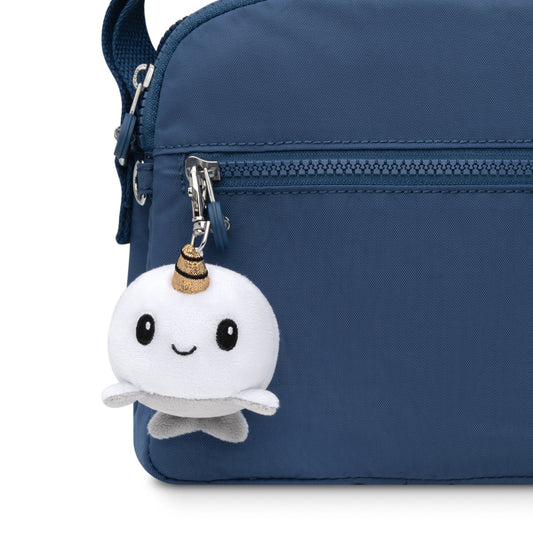 A portable blue purse with a TeeTurtle Narwhal Plushie Charm Keychain attached as a charm keychain.