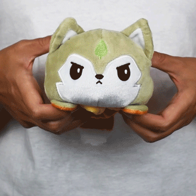 A person holding a TeeTurtle Reversible Wolf Plushie (Spring + Summer) in their hands.