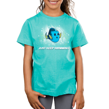 A girl wearing a turquoise t-shirt featuring Dory from Disney/Pixar's "Finding Nemo" that says Just Keep Swimming by Pixar.