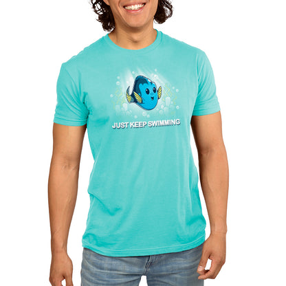 A young man wearing a turquoise t-shirt featuring the officially licensed Disney/Pixar character, Dory from Finding Nemo, called "Just Keep Swimming" by Pixar.