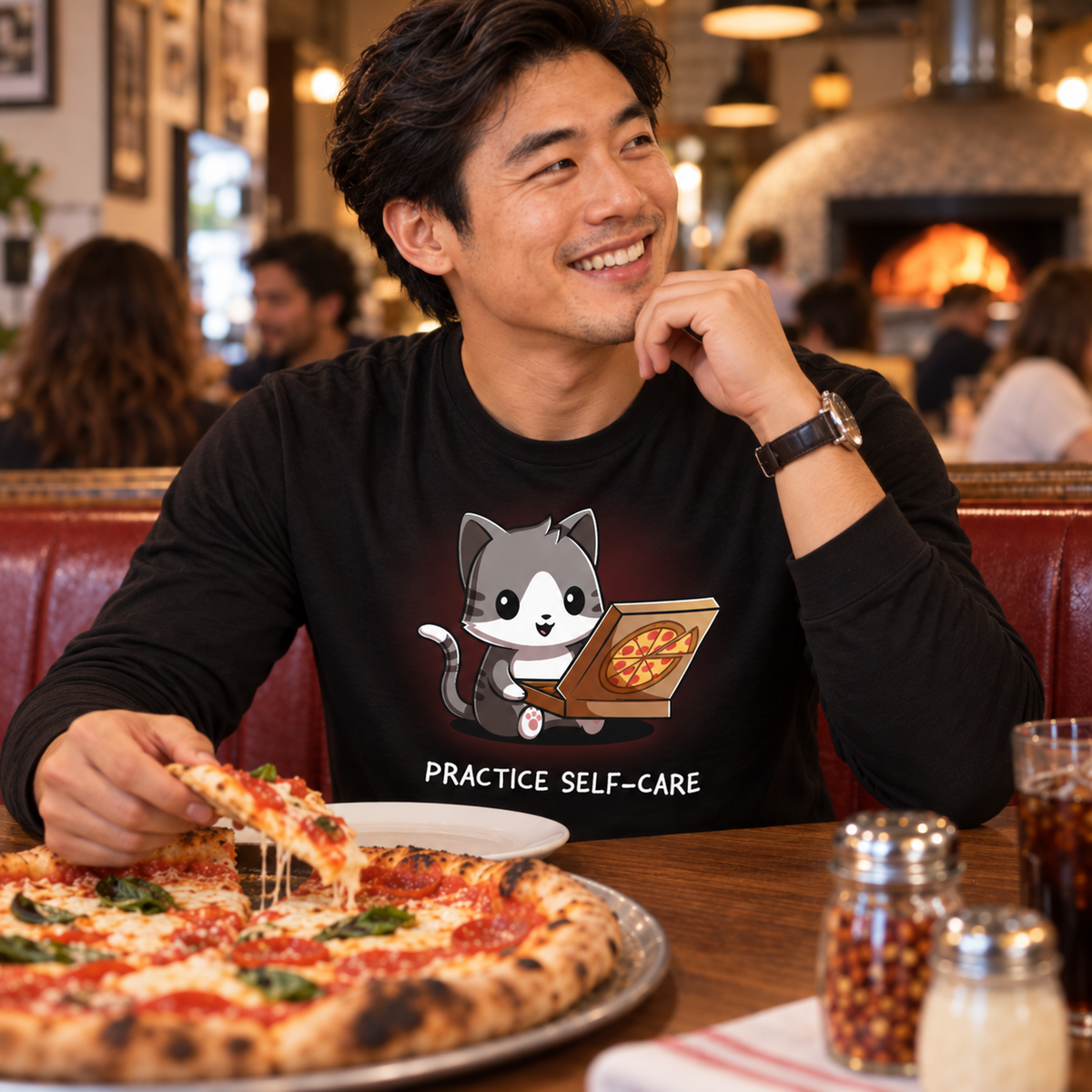Long Sleeve T-shirt_TeeTurtle black Practice Self-Care Long Sleeve T-shirt featuring a happy gray-and-white cat holding an open pizza box with a pepperoni pizza and the text "Practice Self-Care."