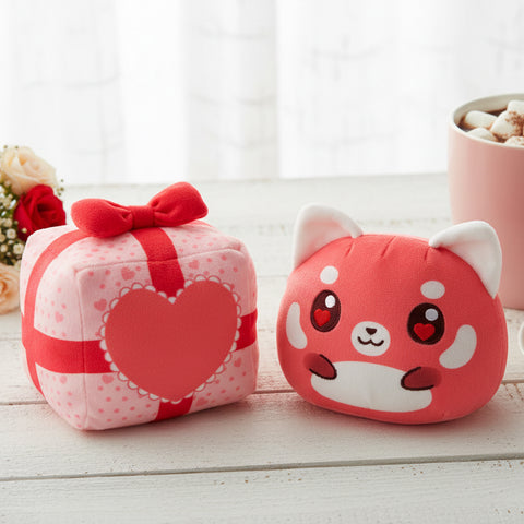 Valentine Present Red Panda 4" Reversible Plushie on a shelf surrounded by roses, and a cup of hot cocoa