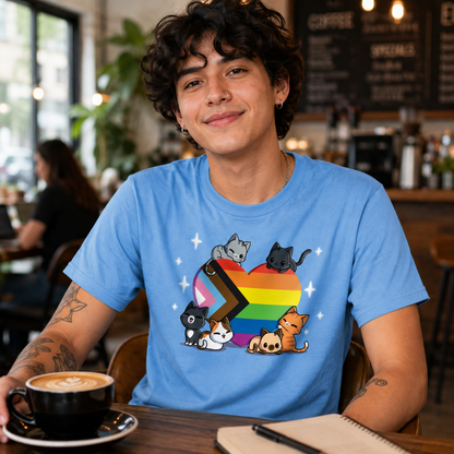 Premium Cotton T-shirt_TeeTurtle light blue Progress Purride Premium Cotton T-shirt featuring six different cats on or around a heart that is the colors of the progress pride flag. There are sparkles around them and all the cats look happy. 