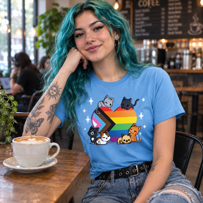Premium Cotton T-shirt_TeeTurtle light blue Progress Purride Premium Cotton T-shirt featuring six different cats on or around a heart that is the colors of the progress pride flag. There are sparkles around them and all the cats look happy. 