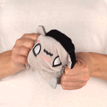 A woman holding a TeeTurtle Reversible Axolotl Plushie (Gray + Black) in her hands.