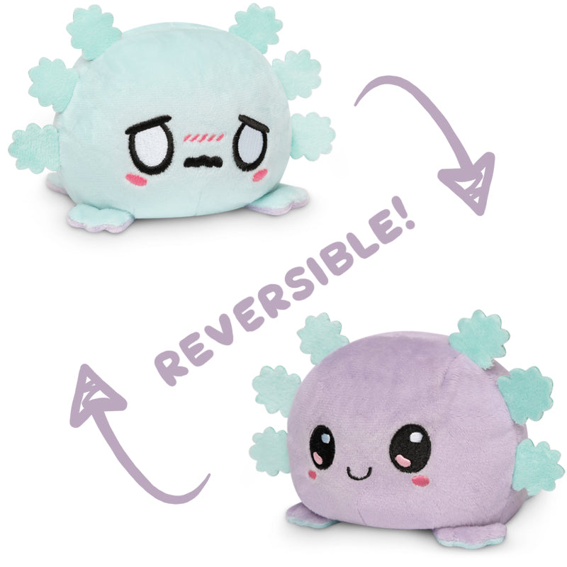 Two reversible plush toys, one being a mood plushie and the other a TeeTurtle Reversible Axolotl Plushie (Light Blue + Light Purple) by TeeTurtle.
