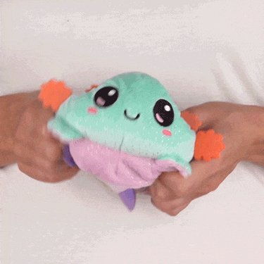 A person cuddling a small TeeTurtle Reversible Axolotl Plushie (Light Purple Sparkle + Aqua Sparkle).