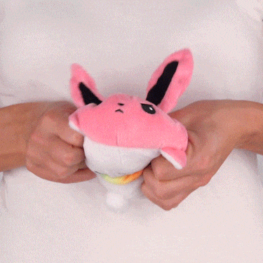 A woman holding a TeeTurtle Reversible Bunny Plushie (Rainbow Ears) by TeeTurtle.