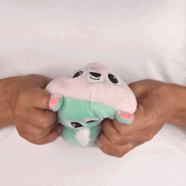 A person holding a TeeTurtle Reversible Deer Plushie in their hands.