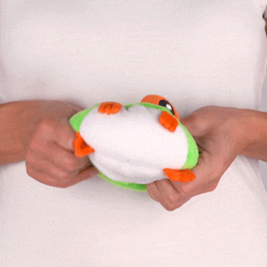 A woman holding a TeeTurtle Reversible Frog Plushie (Tree Frog).