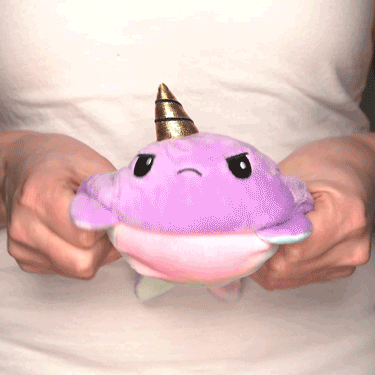 A person holding a TeeTurtle Reversible Narwhal Plushie (Purple + Tie-Dye) by TeeTurtle.
