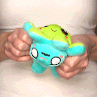 A woman holding a TeeTurtle Reversible Octopus Plushie (Aqua + Light Green) she discovered on TikTok.