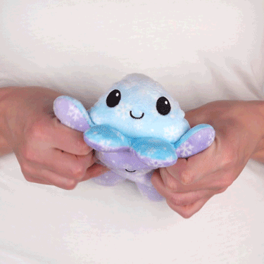 A person showcasing their TeeTurtle Reversible Octopus Plushie (Snowflakes).