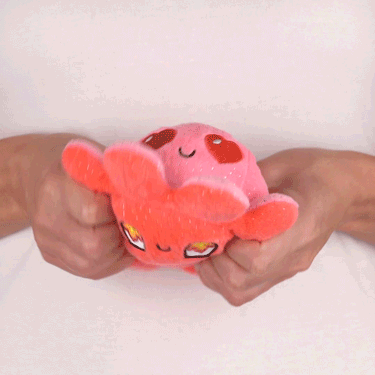 A person holding a TeeTurtle Reversible Octopus Plushie (Red Sparkle + Pink Sparkle), setting a fun TikTok mood.
