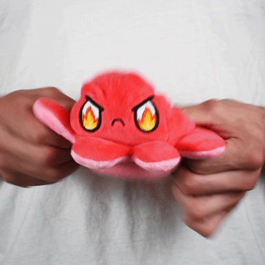 A person holding a TeeTurtle Reversible Octopus Plushie (Red + Pink), showcasing their love for octopus plushies.