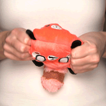 A woman holding a TeeTurtle Reversible Red Panda Plushie (Light Red + Red).