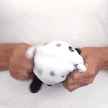 A person holding a reversible TeeTurtle Pochacco plushie by Sanrio.