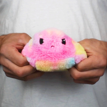 A person holding a TeeTurtle Reversible Ball Plushie (Fuzzy Tie-Dye) by TeeTurtle.