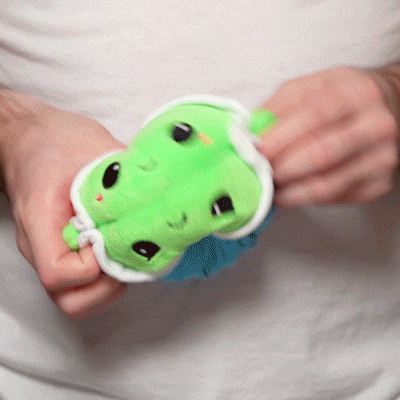 A person holding a TeeTurtle Reversible Turtle Plushie (Blue Shell + Red Shell).