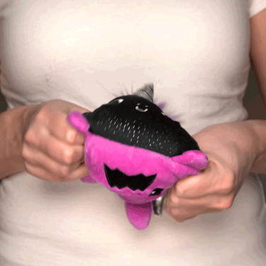 A woman holding a TeeTurtle Reversible Dragon & Unicorn Plushie (Purple + Black Sparkle).