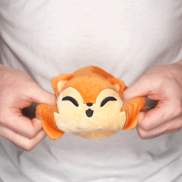 A person holding a TeeTurtle Reversible Werewolf Plushie.
