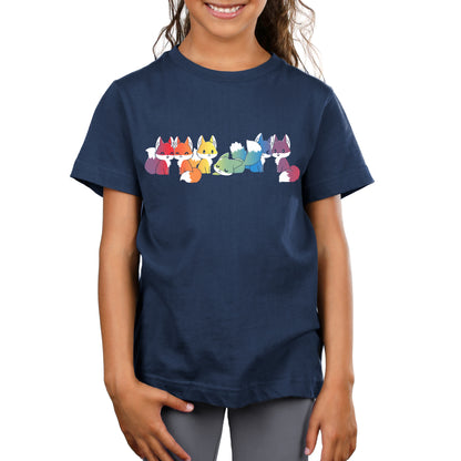 A young girl wearing a navy blue monsterdigital T-shirt featuring nine colorful cartoon foxes in a row, standing and smiling. The girl has long hair and is smiling.