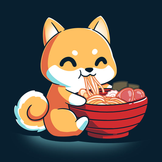 The Ramen Shiba design from monsterdigital features a cute cartoon Shiba Inu dog happily eating a large bowl of ramen noodles with various toppings, all printed on a super soft ringspun cotton navy blue t-shirt. The dark background adds an extra charm to this cozy and stylish tee.