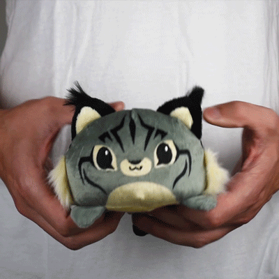 A person holding a TeeTurtle Reversible Lynx Plushie in their hands.