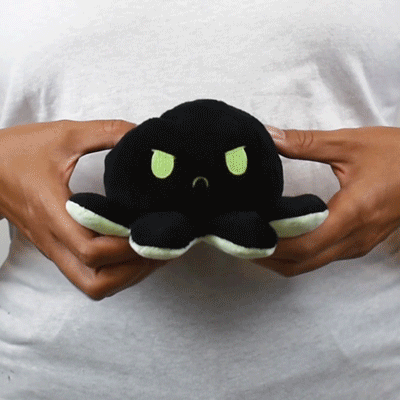 A person holding a TeeTurtle Reversible Octopus Plushie (Black + Green Glow) with various mood expressions.