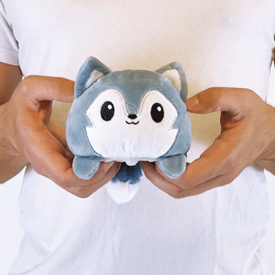 A person holding a TeeTurtle Reversible Wolf Plushie (Gray) from TeeTurtle.