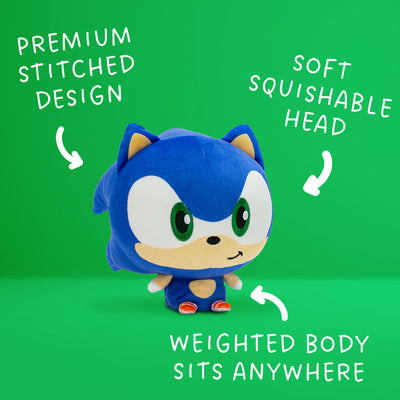 Sonic the Hedgehog Cloudhead - he has a big head, tiny body, and is smirking. Around him are the words "premium stitched design" "soft squishable head" and "weighted body sits anywhere" with arrows pointing to the plushie. 