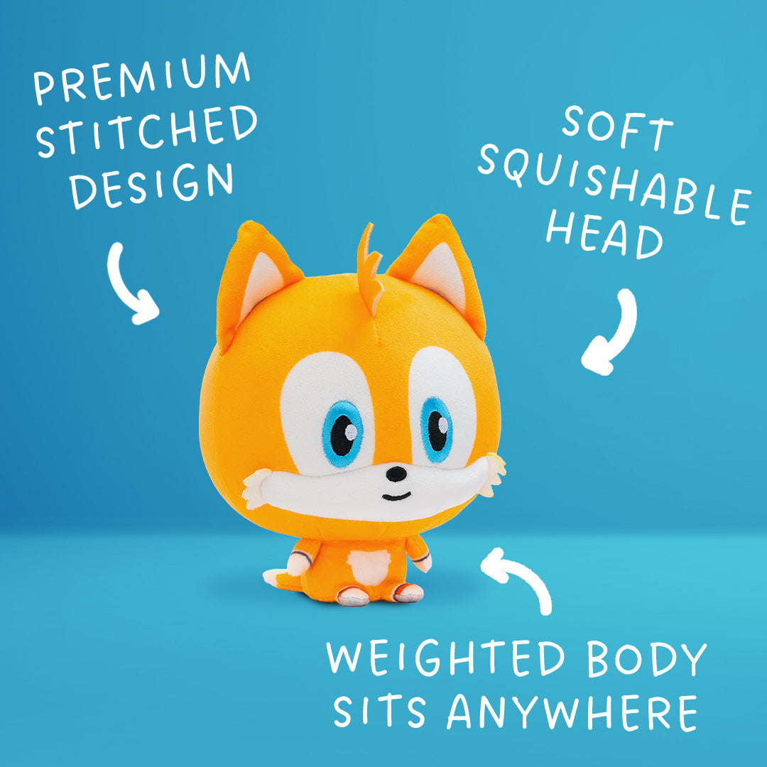 Tails Cloudhead, a plushie with a big head and a tiny body. He has a little smile on his face. Around him are arrows and the text "premium stitched design," "soft squishable head" and "weighted body sits anywhere." 